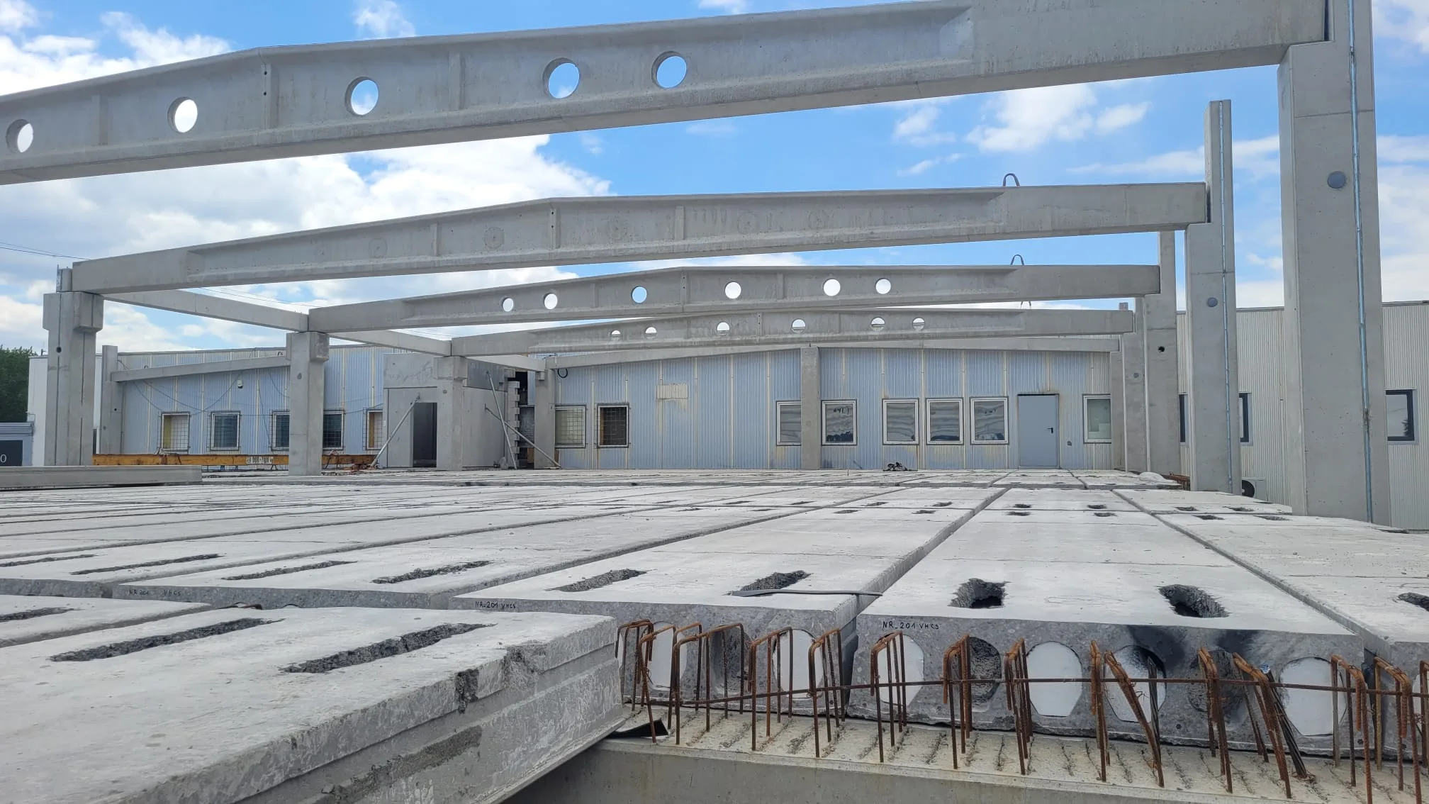 Prefabrykowana konstrukcja z betonowych belek i stropów podczas budowy zakładu produkcyjno-usługowego dla Karmello w Czechowicach-Dziedzicach, generalny wykonawca VSYSTEM