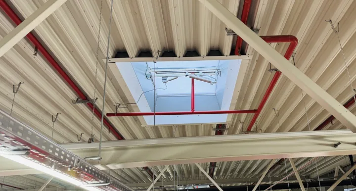 Klapa dymowa zamontowana w dachu obiektu – element oddymiania grawitacyjnego w ofercie VSYSTEM.