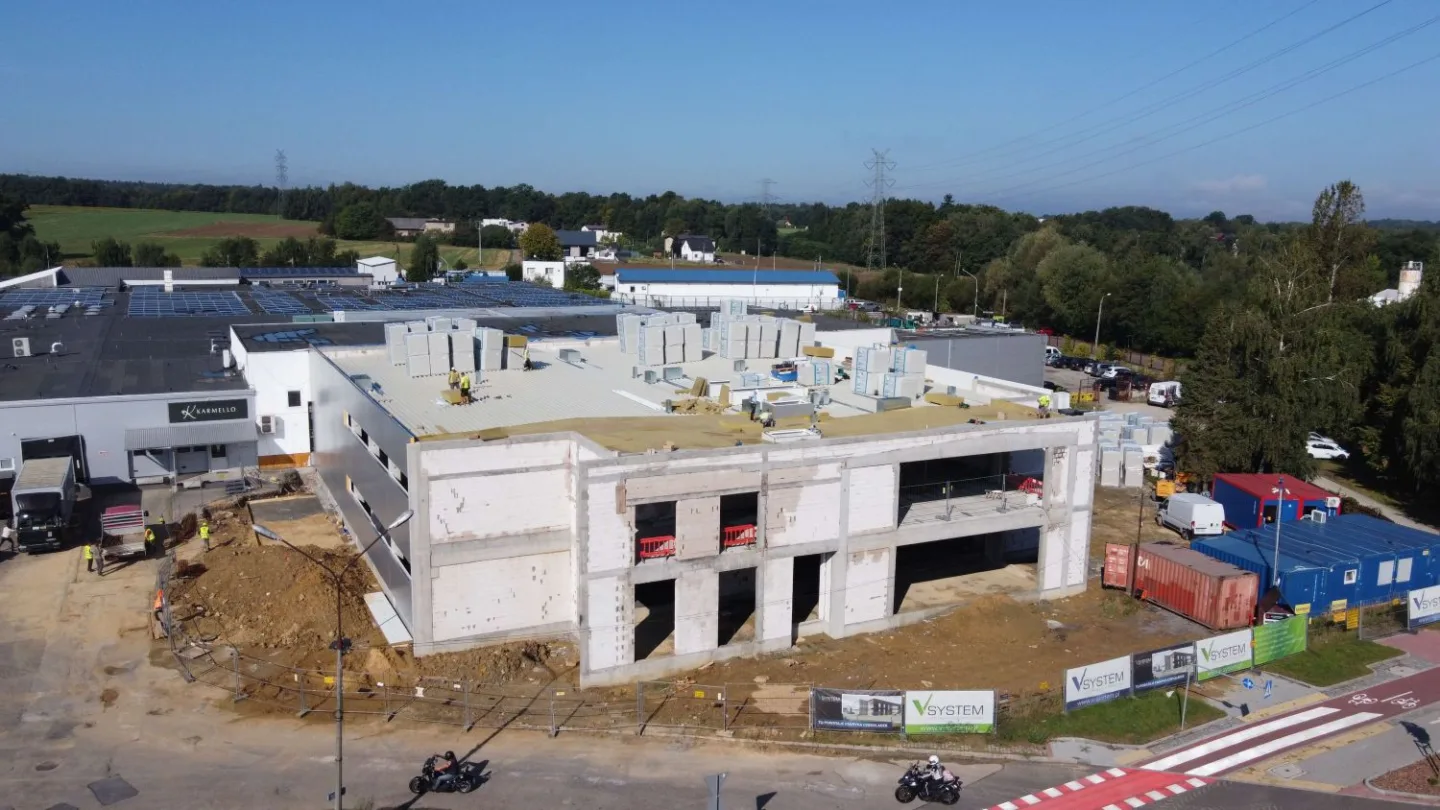 Budynek produkcyjny Karmello Chocolatier w trakcie budowy – widoczna konstrukcja obiektu i prace na dachu, realizacja VSYSTEM w Czechowicach-Dziedzicach
