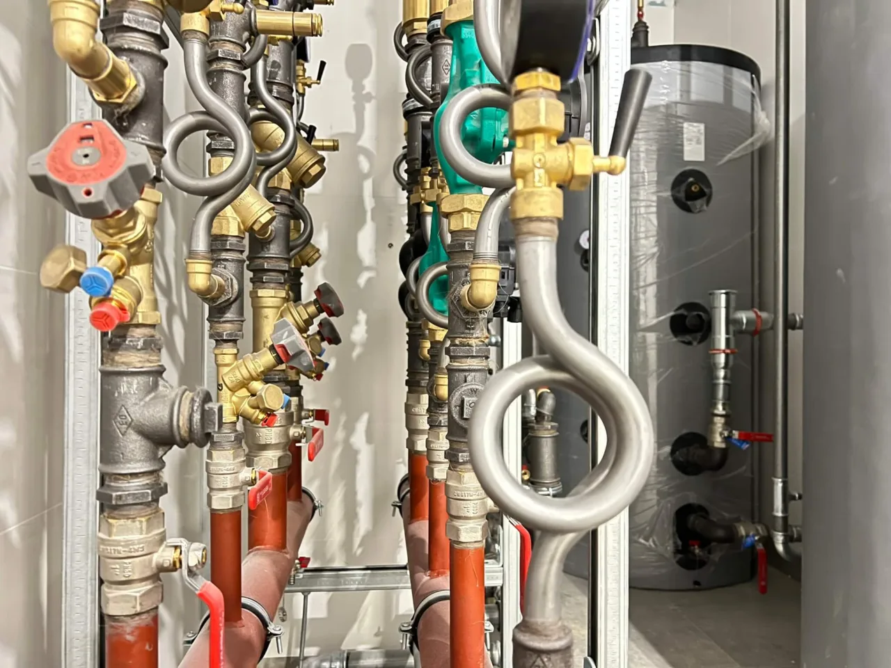 Instalacje sanitarne w budynku Karmello – widoczne elementy instalacji wodnej i grzewczej w pomieszczeniu technicznym
