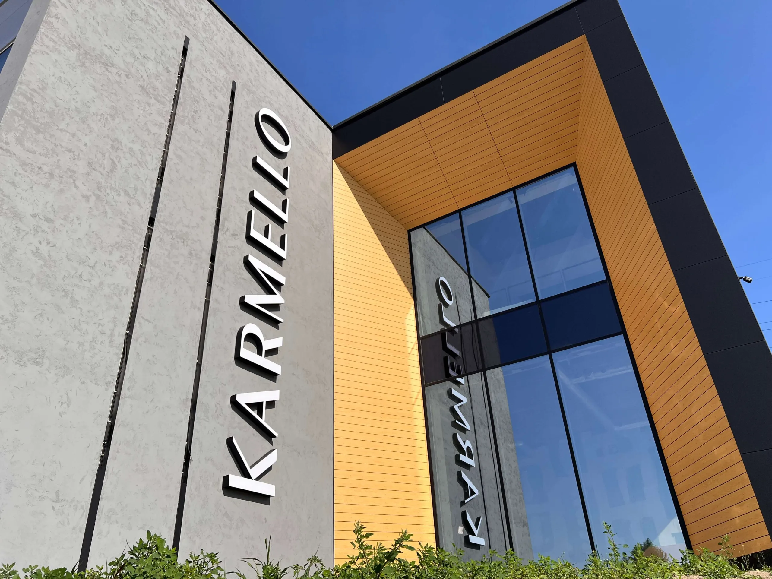 Przestrzenne logo Karmello na elewacji budynku realizowanego przez VSYSTEM