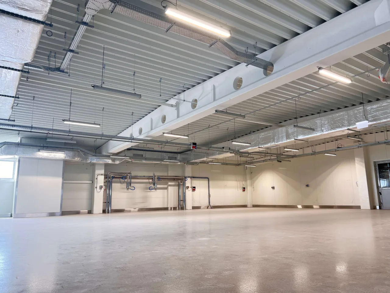 Wnętrze hali produkcyjnej Karmello z wykonanymi instalacjami sanitarnymi, elektrycznymi i wentylacyjnymi przez VSYSTEM
