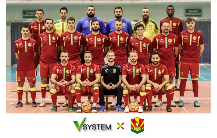 Drużyna Futsal BKS Stal Bielsko-Biała w hali sportowej, poniżej logotypy VSYSTEM i BKS rozdzielone znakiem × — grafika o współpracy sponsorskiej